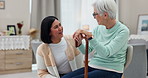 Assisted living, walking stick and a senior woman talking to a carer in a retirement home living room. Conversation, healthcare or medical with an elderly patient and nurse consulting for support
