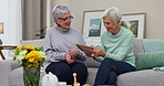 Elderly, women and together with holding photographs in home with happiness for conversation  Happy, sisters and retirement and memory with senior female or friends on sofa with picture frame  house.