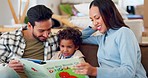 Father, mother and happy child reading books in living room for learning, language development and care. Dad, mom and boy kid relax for quality time of dinosaur storytelling together in family home