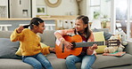 Music, guitar and dance with sister children sitting together on a sofa in the living room of their home for fun. Kids, happy and girl child musician playing an instrument for a sibling in the house