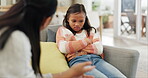 Mother and upset child talking at home about discipline, bad behaviour or psychology problem on a sofa. A woman or psychiatrist with a girl kid in a living room for discussion, advice or lecture