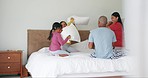 Energy, pillow fight and parents with their girl kids on bed being playful and having fun together. Happiness, smile and children playing with their mother and father in bedroom of their family home.