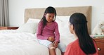 First aid, support and girl a injury and mom with a bandage in bedroom for wound, hurt knee or accident in home. Mother, nursing or helping child on bed with pain, bruise or medical care in house