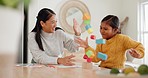 Mom playing with building blocks with her daughter in the kitchen for child development at home. Happy, bonding and young Asian mother helping her daughter with wood toys for fun at their house.