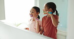 Learning, home or children in bathroom brushing teeth together in a grooming morning routine. Kids, oral care or girls cleaning mouth with toothbrush for dental health, growth or child development