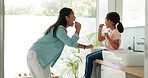 Mother teaching her child to brush her teeth in the bathroom of their modern family home together. Hygiene, wellness and young mom helping her girl kid with her morning mouth routine at their house.