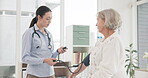 Woman, doctor and blood pressure of senior patient for checkup appointment or consultation at hospital. Female person, medical or healthcare professional monitoring customer in elderly care at clinic