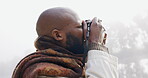 Photography, black man and a camera in nature in the fog for travel, memory and vacation in winter. Calm, professional and an African photographer with gear for taking pictures of the environment