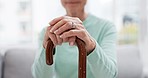 Hands, walking stick and elderly woman with walking stick on a sofa for balance, support and mobility. Walk, aid and old female at senior care facility with disability, dementia or chronic arthritis
