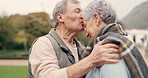 Kiss, forehead and senior couple in a park with love, happy and conversation with romantic bonding. Kissing, old people and elderly man embrace woman with care, romance or soulmate connection outdoor