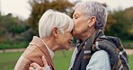 Senior woman kissing her friend on the forehead for affection, romance and bonding on outdoor date. Nature, commitment and elderly female couple in retirement with intimate moment in garden or park.