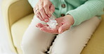 Medicine, pills and hands of old woman on sofa for prescription, medical and supplements. Healthcare, wellness and vitamins with closeup of person in living room at home for pharmacy and retirement