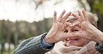 Senior happy woman, heart hands and nature for love, care or romance in outdoor forest or park. Portrait of elderly female person smile with loving emoji, sign or shape in symbol for romantic gesture