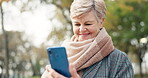 Phone, communication and a senior woman in the park, looking for a social media post on an app. Mobile, smile and text message with a happy elderly female person reading an sms in an outdoor garden