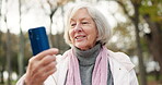 Phone, video call and a senior woman in the park, chatting on an app for long distance communication. Mobile, wave and smile with a happy elderly female person chatting while in an outdoor garden