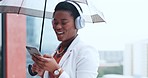 Umbrella, music and business woman in city with phone for streaming song, audio and radio in urban town. Rain, corporate and female person in winter with headphones for travel, commute and journey