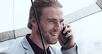 Phone call, happy and businessman with an umbrella in the city while walking to the office in a street. Technology, communication and young professional male person on mobile conversation in town.