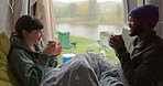 Camping, coffee and a happy couple with a toast in the morning for a road trip and relax. Laughing, interracial and a black man and woman in transport with tea during a vacation in the countryside