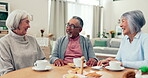 Senior people, friends and drinking tea and talking at a table in a retirement home. Elderly women and a man at a table with coffee and cookies for bonding, laugh and quality time or relax together