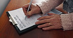 Senior woman, hands and writing on retirement documents for life insurance, will or pension on desk. Closeup of elderly female person sign or filling paperwork, form or legal application on table