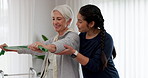 Woman, nurse and elastic band in elderly care for fitness, physiotherapy or workout at old age home. Female person, caregiver or physiotherapist helping senior patient in resistance or exercise