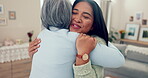 Love, retirement and a senior asian woman hugging her daughter in the living room of a home during a visit. Family, smile and an adult child embracing her happy mother together in an apartment