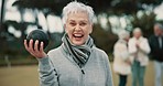 Senior woman, lawn bowling and park with face for sport, fitness or game for competition, health or fun. Elderly lady, metal ball and grass for contest, excited smile or workout in outdoor portrait