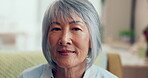 Face, retirement and happy with a senior asian woman in the living room of her home closeup. Portrait, wrinkles and gray hair with an elderly female pensioner sitting in her house to relax alone