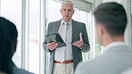 Senior businessman, tablet and presentation in meeting for coaching, planning or teamwork collaboration at office. Executive man, CEO or speaker talking to business team or training staff in workshop