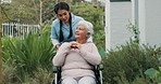 Talking, garden and a caregiver with a woman in a wheelchair for healthcare and morning walk. Happy, nursing home and a nurse speaking to a senior patient with a disability on the lawn for care