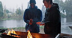 Fire, warm hands and friends on camping adventure, trip or outdoor for a bonfire in the woods, forest or countryside. Campfire, flame and couple or men relax together on winter vacation in nature