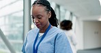 Black woman, doctor and tablet while walking in a hospital, planning and greeting coworkers in lobby. Healthcare, hello and African female health expert check online schedule to start clinic consult