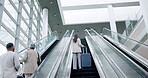 Airport, luggage and the back of business people on an escalator for international travel or transport. Corporate, global and professional employees in a terminal, leaving for a trip or journey