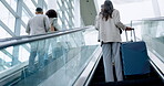 Airport, suitcase and the back of business people on an escalator for global travel or transport. Corporate, international and professional employees in a terminal, leaving for a trip or journey