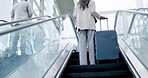 Airport, luggage and the back of a business employee on an escalator for international travel or transport. Corporate, global and professional people in a terminal, leaving for a trip or journey