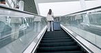 Airport, luggage and back view of business people on an escalator for international travel or transport. Corporate, global and professional workers in a terminal, leaving for a trip or journey
