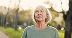 Senior woman, happy and thinking outdoor in a park with happiness, positive mindset and a smile. Face of elderly person in nature, forest or woods for fresh air, health and wellness in retirement