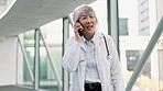 Phone call, telehealth and female doctor in the hospital walking in the corridor talking on mobile. Technology, woman and senior Asian healthcare worker doing online medical consultation on cellphone