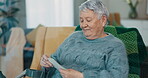 Photograph, senior woman and memory on a home sofa for nostalgia, history and to remember. An elderly female person with pictures while thinking of old album, nostalgia and photography in retirement