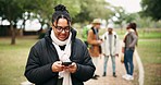 Smartphone, woman and typing in nature for hiking, travel and adventure outdoor. Phone, happy and African person in countryside, park or forest for social media, internet or online for winter holiday