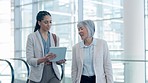 Business people, tablet and travel schedule for women walking in an airport checking schedule. Meeting, brief and female team online for airplane information, compliance or reading flight details