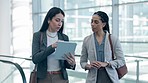 Business, tablet and travel schedule for women walking in an airport checking schedule together. Meeting, brief and female team online for airplane information, compliance or reading flight details