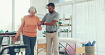 Man, physiotherapy and patient walking in elderly care for physical therapy or assessment at the clinic. Male medical physiotherapist or caregiver helping senior woman to walk in healthcare support