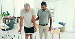 Man, physiotherapy and senior patient with walker in elderly care for walking exercise or therapy at clinic. Professional male medical physiotherapist helping mature person with a disability to move