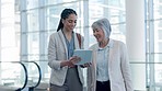 Travel, tablet and business people in an airport talking, planning and checking flight information. Team, strategy and senior woman with colleagues online for schedule, management and meeting brief 