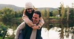 Couple piggyback, laughing and in nature for holiday, summer love and playing together. Smile, care and young man and woman with freedom, quality time and playful by a lake during a camping vacation