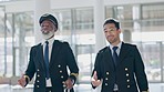 Pilot, mentor and senior man with colleague in airport walking, talking and enjoy planning, conversation and strategy discussion. Airplane, men and elderly male captain intern before boarding flight