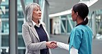 Hospital, doctor and senior woman with handshake, welcome and greeting with kindness, respect and trust. Female person, pensioner and medical professional shaking hand, healthcare and consultation