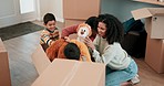 Moving, toys and family with cardboard boxes in their new home bonding and playing together. Happy, smile and young parents being playful with teddy bears with their boy children in a modern house.