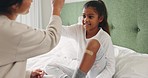 Adhesive bandage, high five and a woman with her daughter in the home bedroom for injury treatment. Support, motivation or trust with a mother and girl child on the bed for help after an accident